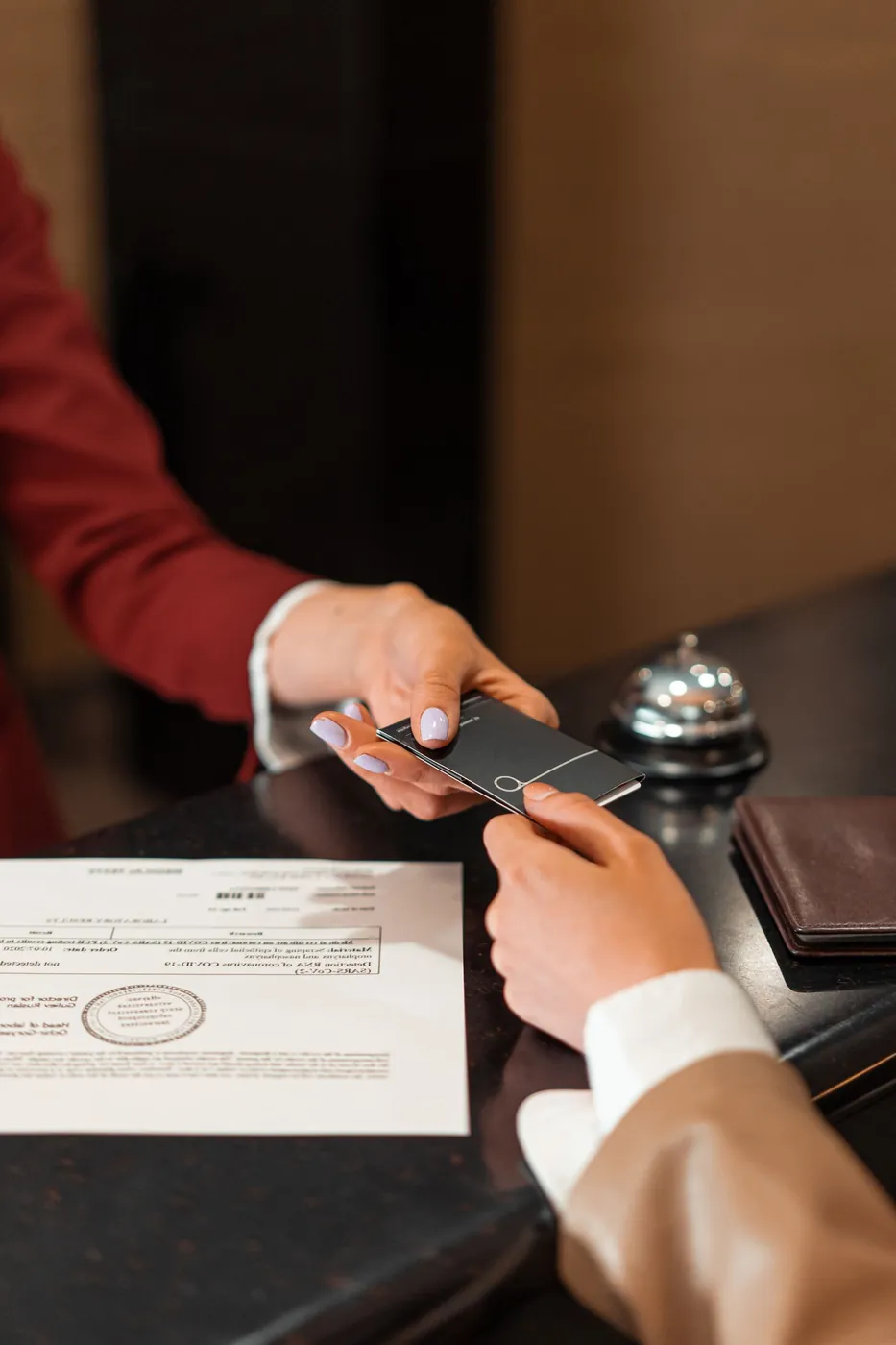 A receptionist handing a key card to an arriving guest