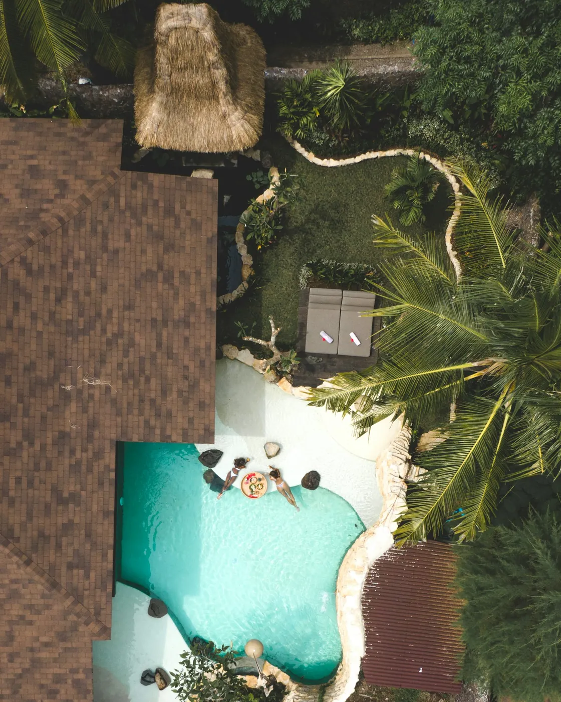 Aerial view of a Balinese villa with a thatched roof and a private jungle pool, the kind of leasehold asset whose resale value tracks its remaining term